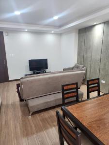 a living room with a couch and a flat screen tv at new apartment in Cochabamba