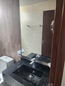 a bathroom with a sink and a toilet and a mirror at new apartment in Cochabamba
