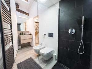 a bathroom with a toilet and a glass shower at Centro storico- Suite silenziosa, Wi-Fi & Netflix in Varese