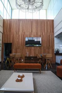 Un vestíbulo con un banco y un televisor en la pared. en Amazon Park Hotel, en Belém