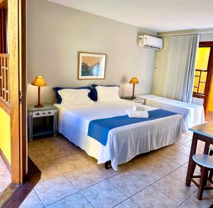 two beds in a room with two tables and two lamps at Pousada das Pedras Paraty -RJ in Paraty +51 photos