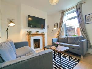 ein Wohnzimmer mit zwei Sofas und einem Kamin in der Unterkunft Charming 3-bed Home Near Centre Free Parking in York