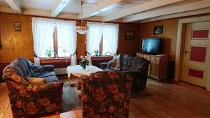 a living room with two chairs and a tv at Petterstuggu in Røros