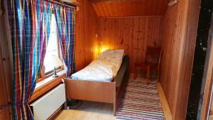 a small room with a bed and a window at Petterstuggu in Røros