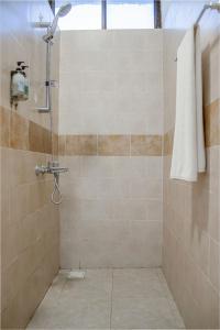 une salle de bain avec une douche avec une serviette au mur dans l'établissement Nungwi Garden Boutique Hotel, à Nungwi