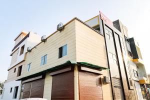 博帕尔Hotel O Kanha Stay的一座带有大车库的高大白色建筑