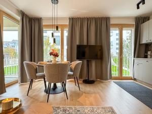 a dining room with a table and chairs and a television at Studio Apartments Lumper Höhe in Ravensburg