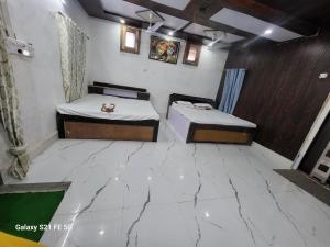 a room with two beds and a marble floor at Punjabi arora house in Vrindāvan