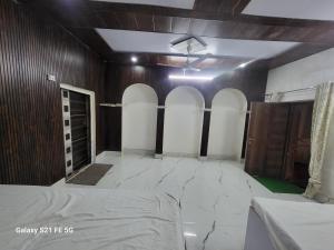 a room with a bed and a wall with arches at Punjabi arora house in Vrindāvan