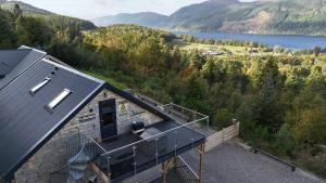 Una vista aérea de una casa con balcón y un lago. en The Loft at Log Ness, en Inverness