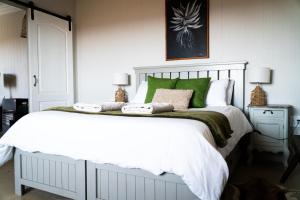 a bedroom with a large white bed with green pillows at Motubane Guest Farm in Madeteleli +46 photos