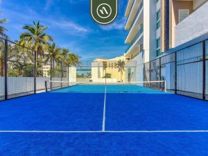 a tennis court in front of a building at New 2 BR Condo One Street From Beach - Pool - Gym in Nuevo Nayarit