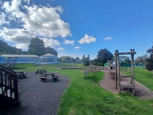 an empty park with picnic tables and a playground at Bucklands - Chalet 15 in Westward Ho