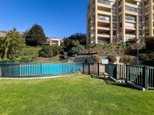 a fence around a pool in a yard with a building at Maravilloso depto. para 5 - vista al mar in Lilén