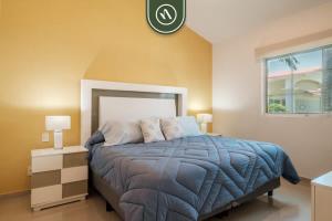 une chambre avec un lit et une horloge au mur dans l'établissement 2BR Condo in Acapulco with Private Patio - Pool, à Acapulco 30 autres photos