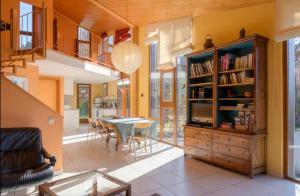 a living room with a book shelf and a dining room at Gîte du Kiwi in Luttenbach-près-Munster