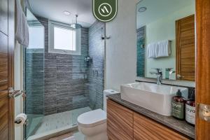 a bathroom with a toilet and a sink and a shower at New 2 BR Condo One Street From Beach - Pool - Gym in Nuevo Nayarit +26 photos