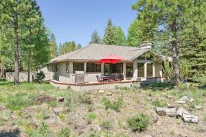 a house with a porch with a red umbrella at 10 Tan Oak in Sunriver