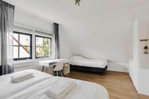 ein Schlafzimmer mit zwei Betten und einem Schreibtisch und einem Fenster in der Unterkunft Vakantiepark Schoorlse Duinen in Schoorl