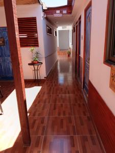 korytarz w domu z podłogą wykonaną z drewna w obiekcie Hostal Siete Colores w mieście San Pedro de Atacama