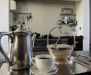 a tea kettle and a cup of coffee on a counter at De Hoffstee in Minnertsga