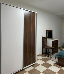 a bedroom with a sliding door and a chair at Down Town Apartment 2 in Gjilan +8 photos