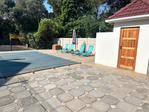 un patio con 2 sillas azules y una piscina en The Morrison on Msasa, en Randburg