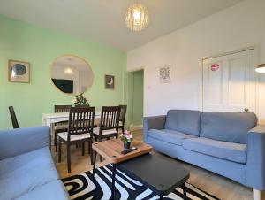 ein Wohnzimmer mit einem blauen Sofa und einem Tisch in der Unterkunft Charming 3-bed Home Near Centre Free Parking in York