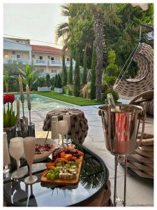 a table with a plate of food and wine glasses at villa MEDITERAN in Pefkochori