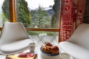 una mesa con un plato de comida y dos sillas en Résidence du Brévent - Chamonix Village, en Chamonix-Mont-Blanc