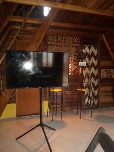 un grande schermo su un supporto in una stanza con sgabelli di chalé alpino a Saquarema