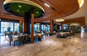 a dining room with tables and chairs in a building at Iliria Hill Resort & Spa in Orllan