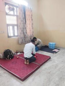 two men kneeling on the floor in a room at Nidhivan Vatika Ashram in Vrindāvan +18 photos