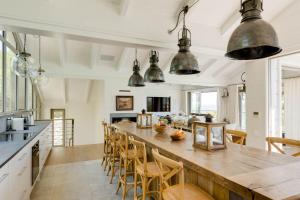 una grande cucina con un grande tavolo in legno e sedie di Bungalow Kloof a Città del Capo Altre 9 foto