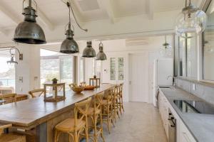 una cucina con un lungo bancone con sedie e un frigorifero di Bungalow Kloof a Città del Capo