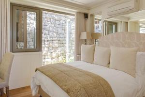 una camera da letto con un grande letto bianco e una finestra di Bungalow Kloof a Città del Capo