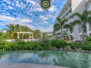 ein Hotel mit einem Swimmingpool vor einem Gebäude in der Unterkunft Luxury Condo with Canal View - Near Beach in Nuevo Nayarit