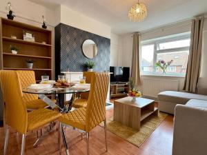 a living room with a table and chairs and a couch at Bright & Lovely Apartment in Chelmsford in Chelmsford