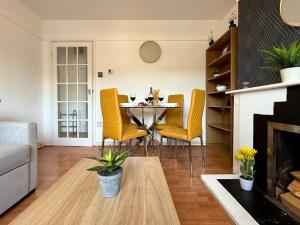 a living room with a table and yellow chairs at Bright & Lovely Apartment in Chelmsford in Chelmsford