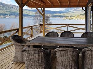 a table and chairs on a deck with a view of a lake at 8 person holiday home in Svelgen in Svelgen +42 photos