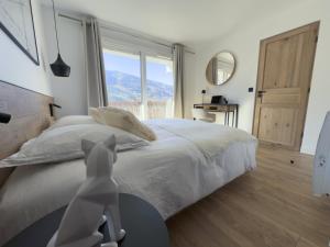 a bedroom with a bed and a large window at Appartement rénové à Méribel Centre, avec Balcon et à 5 minutes des pistes et du centre in Méribel