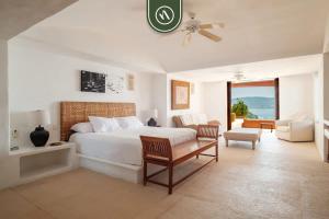 a bedroom with a bed and a living room at 4 BR Penthouse - Breathtaking Views - Private Pool in Ixtapa +52 photos