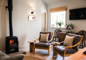 a living room with a wood stove and chairs at Neddy Meadow in Grinton