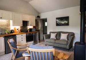 a kitchen and living room with a couch and chairs at Neddy Meadow in Grinton