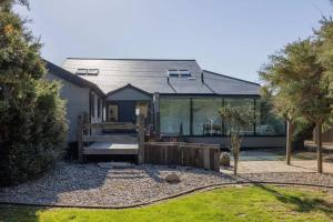 une maison avec une clôture dans la cour dans l'établissement Luxury Seafront Family Home - Indoor Pool, à Earnley