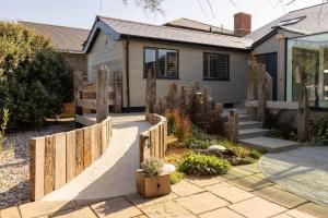 une maison avec une clôture avec des poteaux en bois dans l'établissement Luxury Seafront Family Home - Indoor Pool, à Earnley