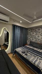 a bedroom with a large bed and a mirror at Studio at walking distance from airport in Pune