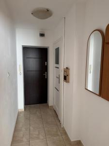 a hallway with a black door and a tile floor at Stare Miasto 10 in Malbork
