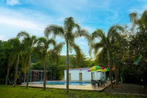 a house with a pool and a colorful umbrella at Rio Royale in Bhimashankar