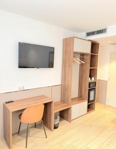 a room with a desk and a television on a wall at Lh HOTELS in Milan